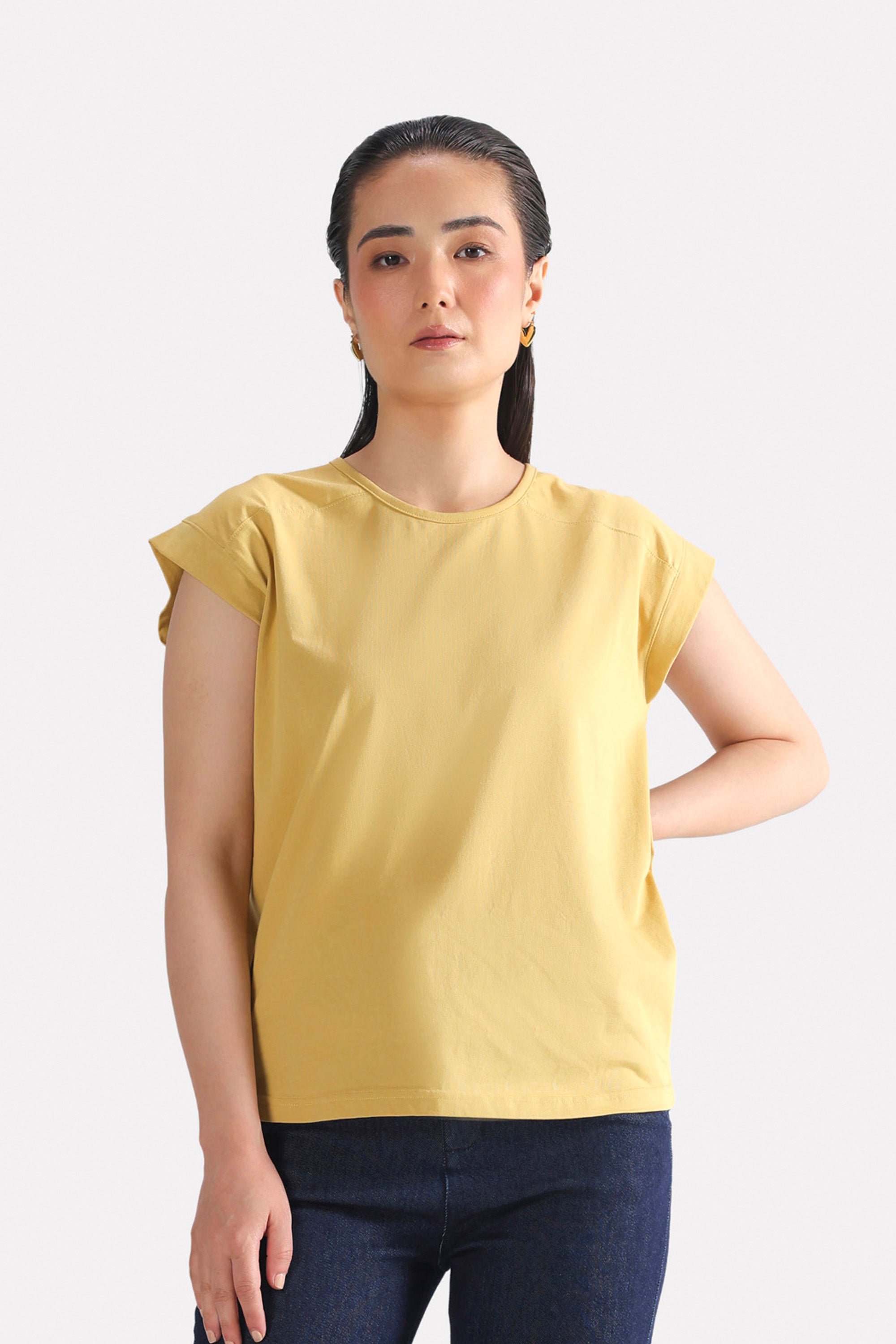 Beige relaxed shoulder-tab t-shirt in cotton, worn by a model, by SOLA Pakistan.