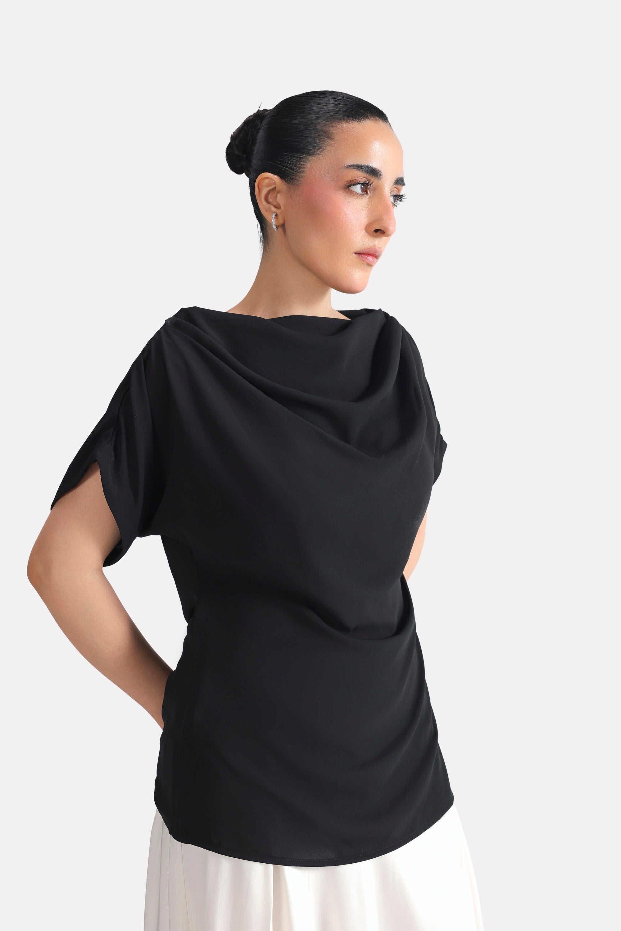 Flat lay of the black batwing sleeve top, by SOLA Pakistan.