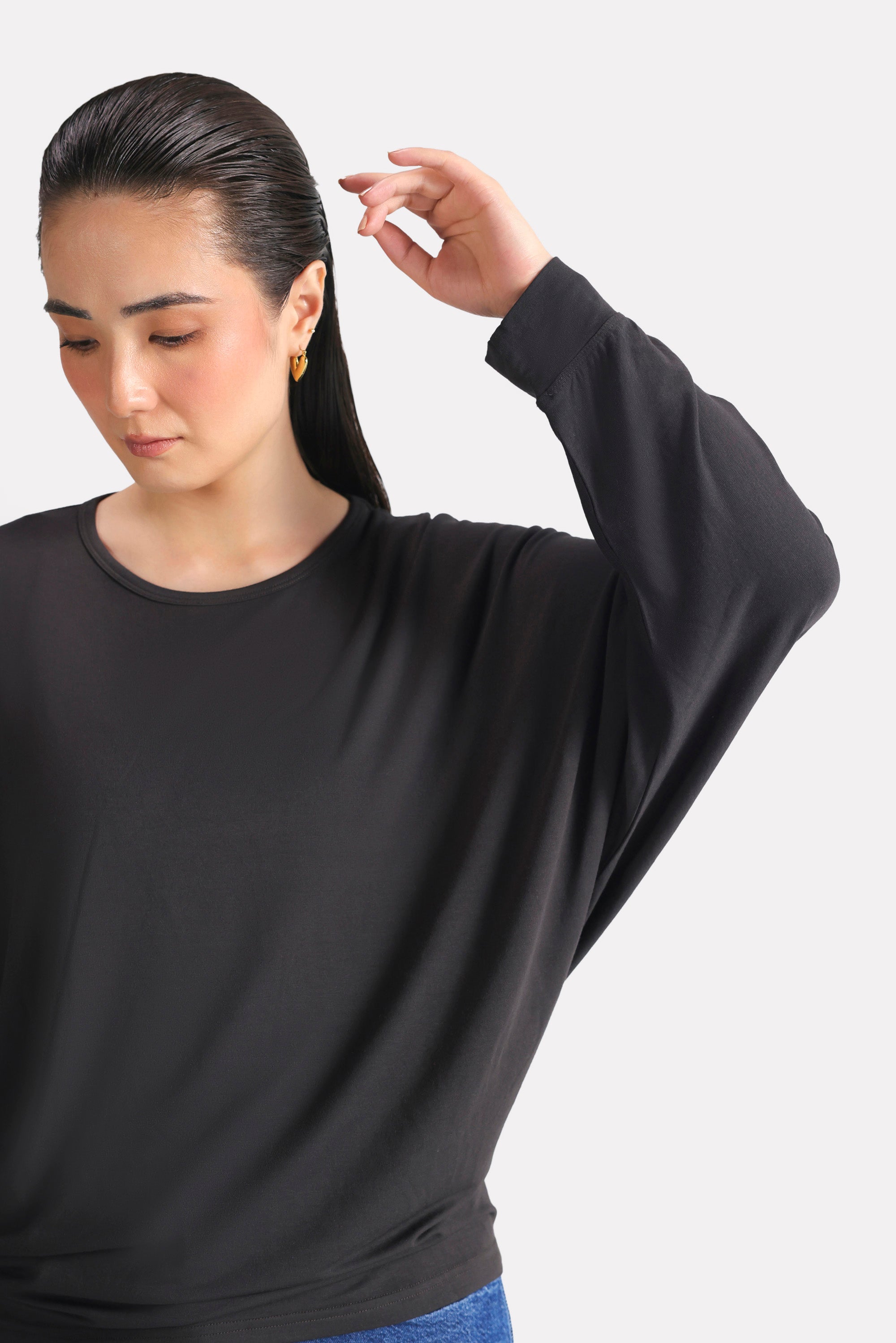 Black fluid sleeve t-shirt shown in a styled fit, by SOLA Pakistan.