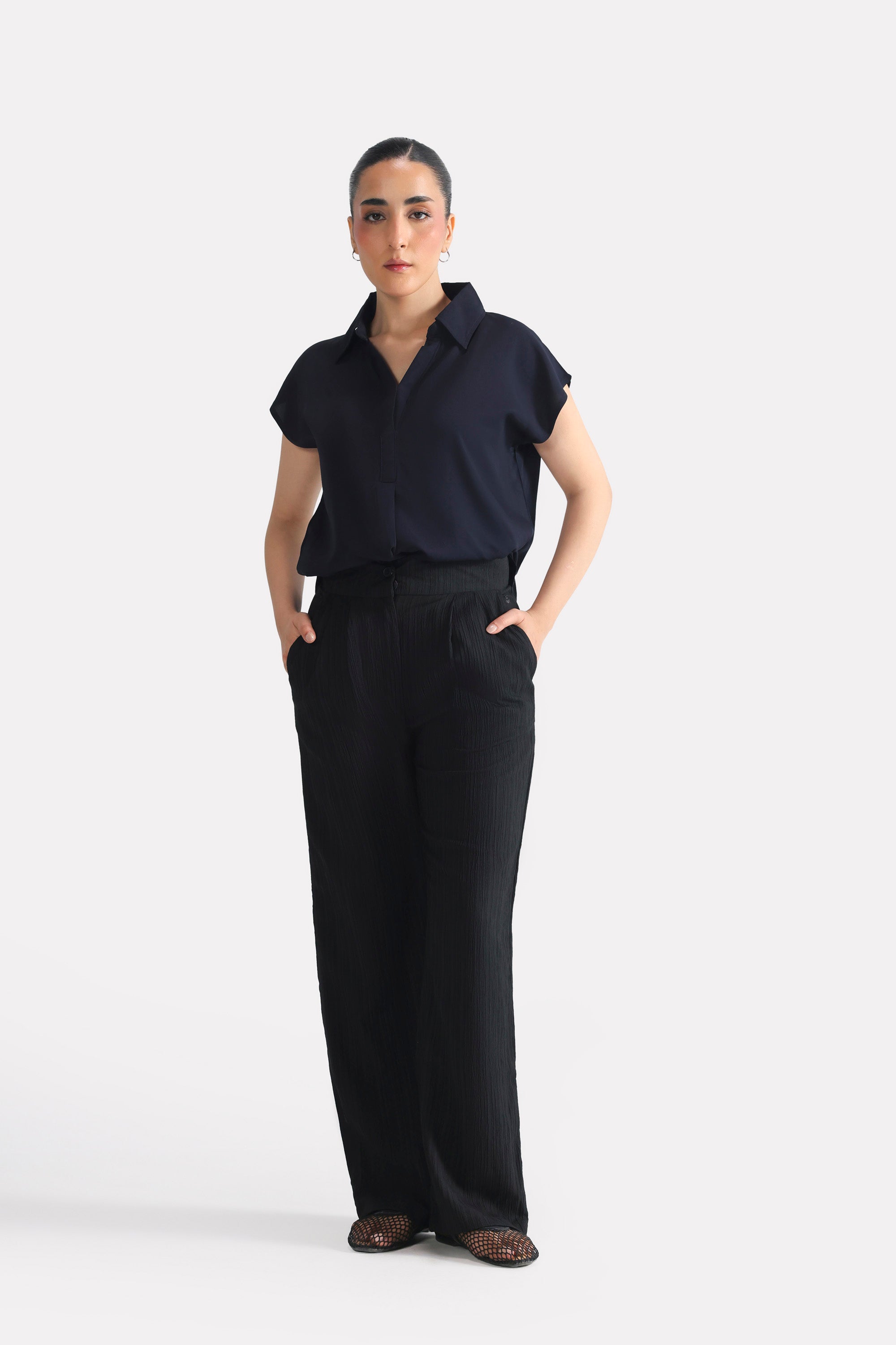 Black retro wide-leg trouser in polyester crepe, worn by a model, by SOLA Pakistan.