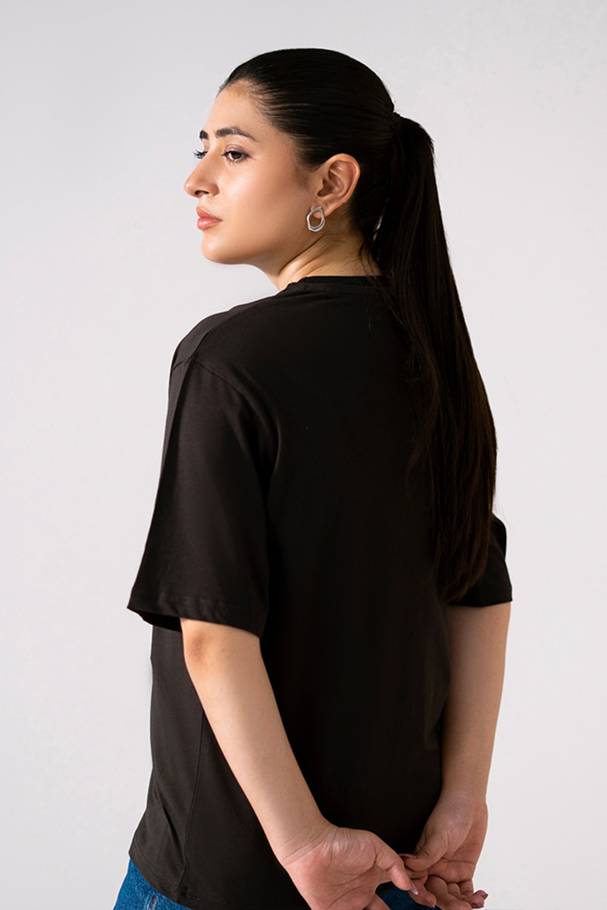 Black round neck t-shirt shown in a styled fit, by SOLA Pakistan.