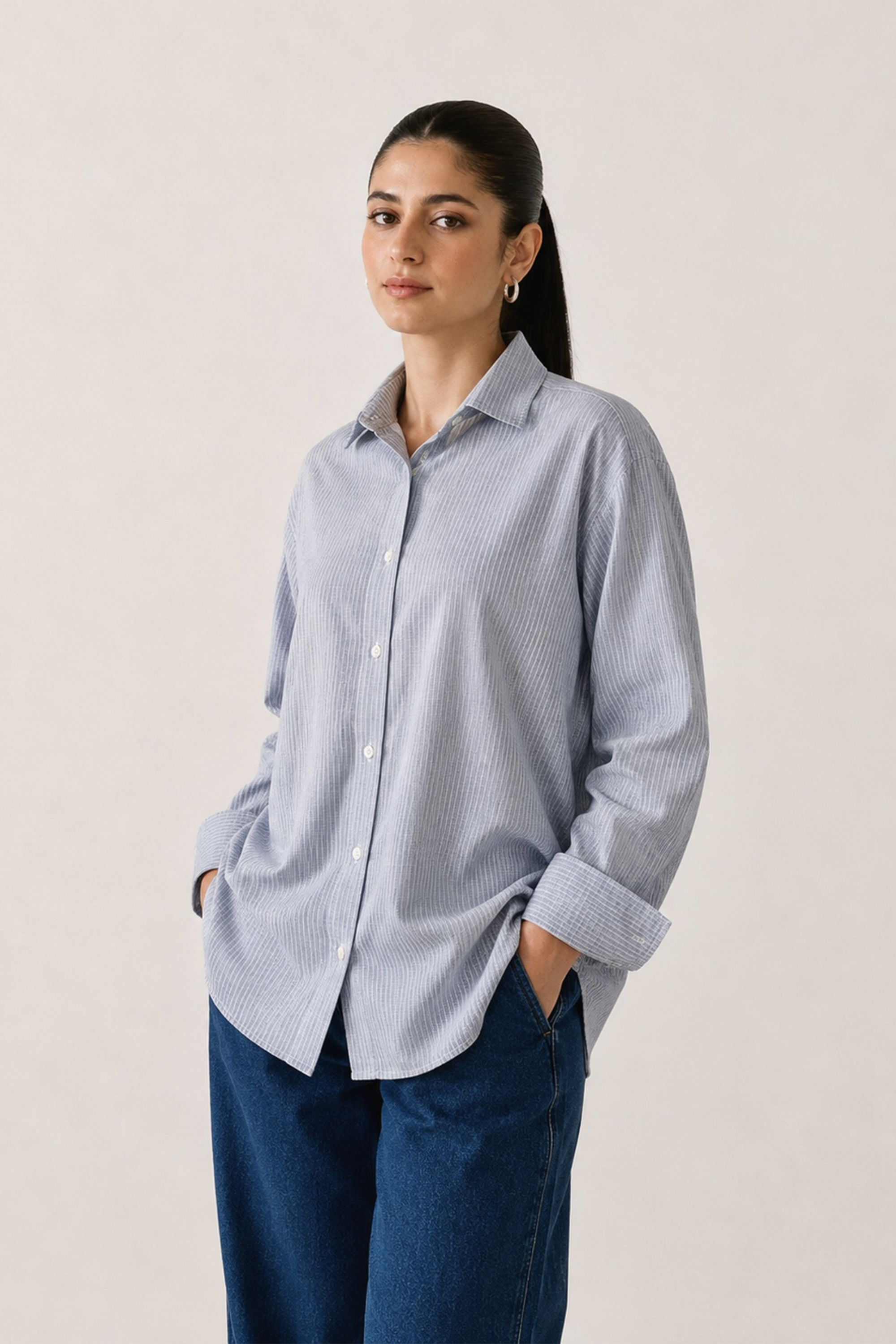 Blue stripe button-up stripe shirt in cotton, worn by a model, by SOLA Pakistan.