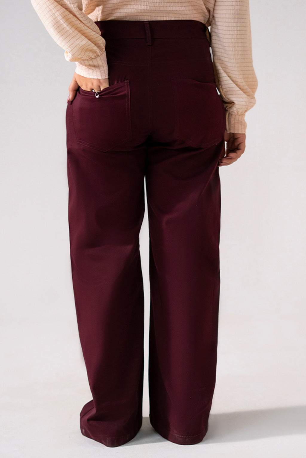 Close-up detail on the dark purple (plum) flared pant, by SOLA Pakistan.