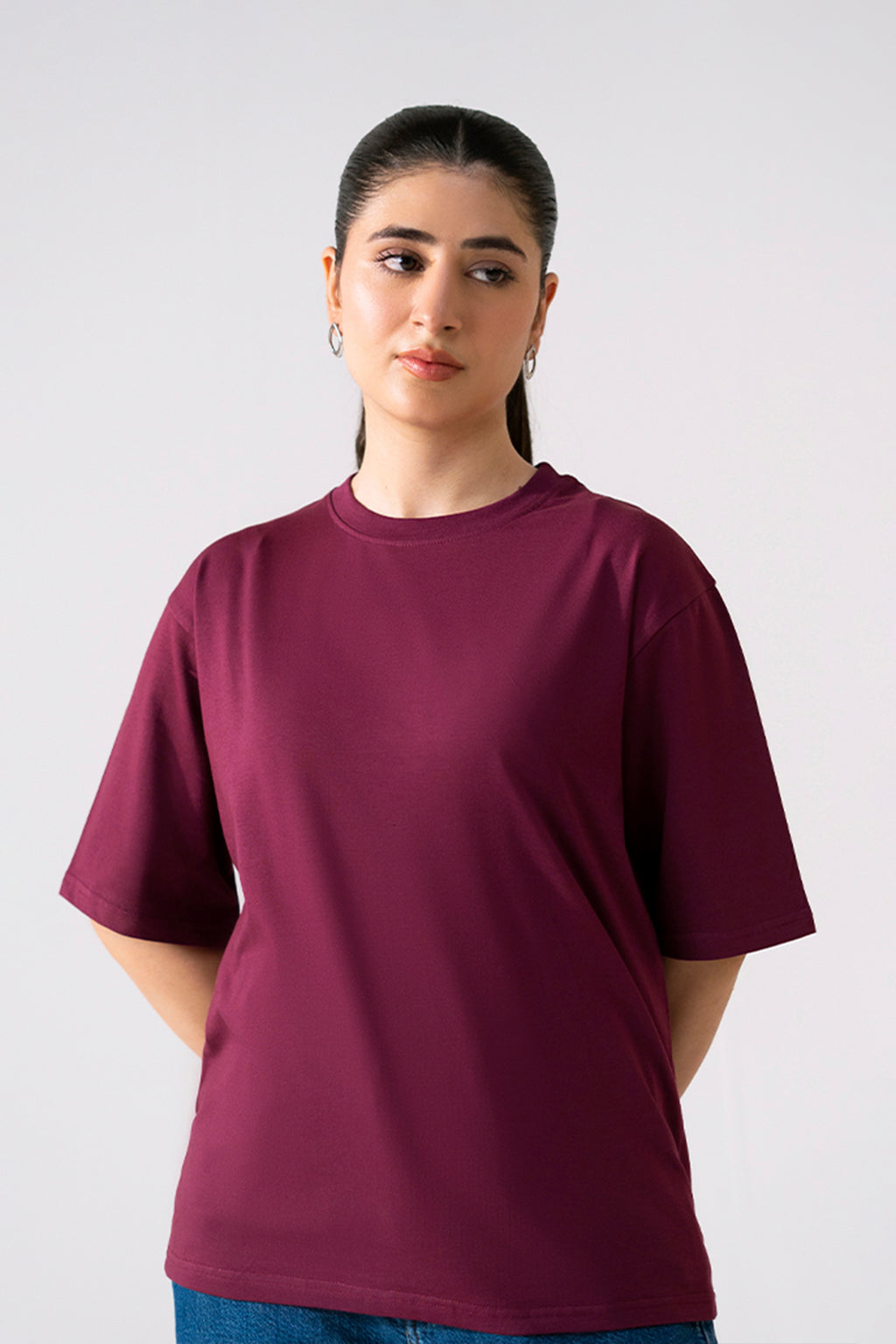 Dark red (burgundy) round neck t-shirt in cotton, worn by a model, by SOLA Pakistan.