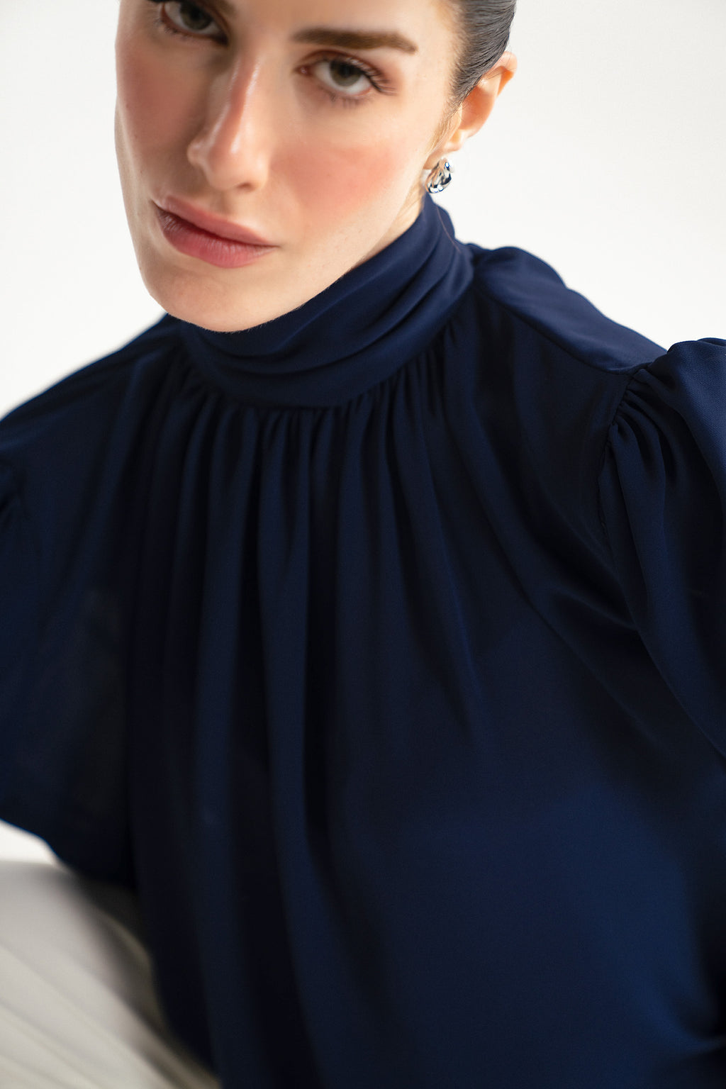 Flat lay of the navy blue gathered highneck blouse, by SOLA Pakistan.