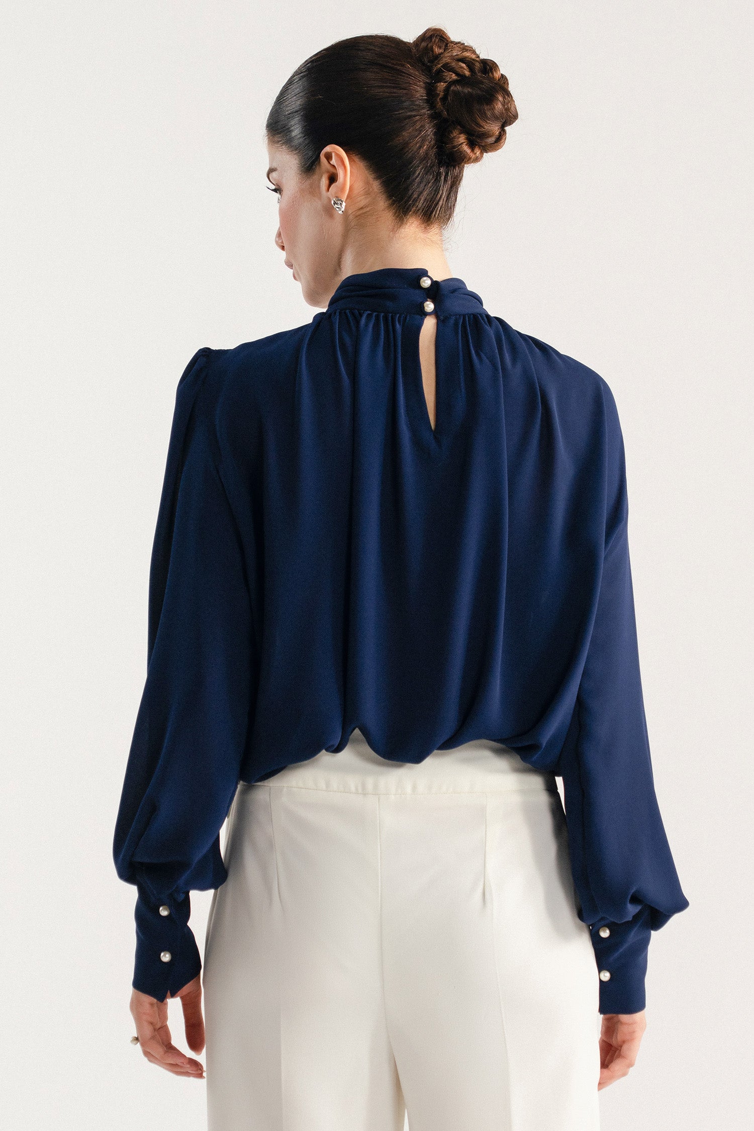 Navy blue gathered highneck blouse shown in a styled fit, by SOLA Pakistan.