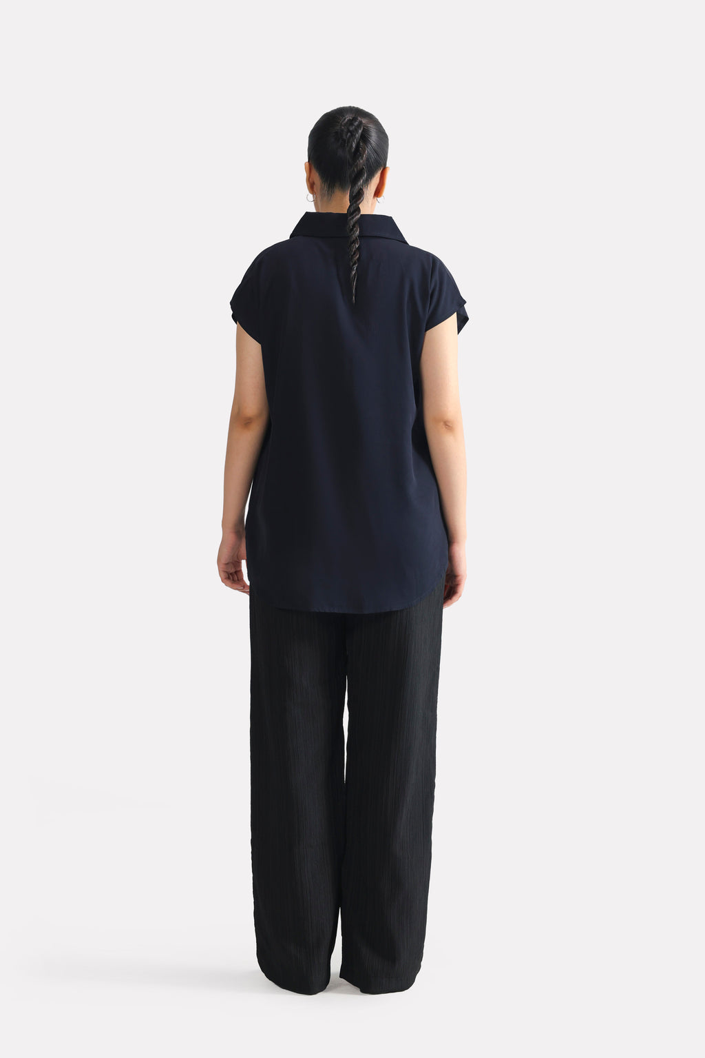Flat lay of the navy blue minimal cap sleeve woven shirt, by SOLA Pakistan.