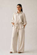 Off white cinched waist bottom in cotton-linen blend, worn by a model, by SOLA Pakistan.