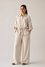 Off white cinched waist bottom in cotton-linen blend, worn by a model, by SOLA Pakistan.