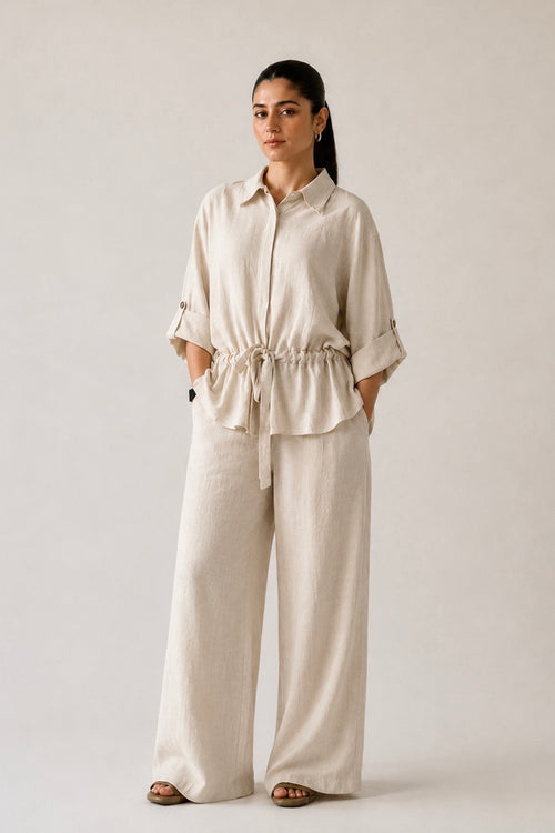 Off white cinched waist bottom in cotton-linen blend, worn by a model, by SOLA Pakistan.
