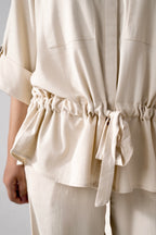 Close-up detail on the off white cinched waist top, by SOLA Pakistan.