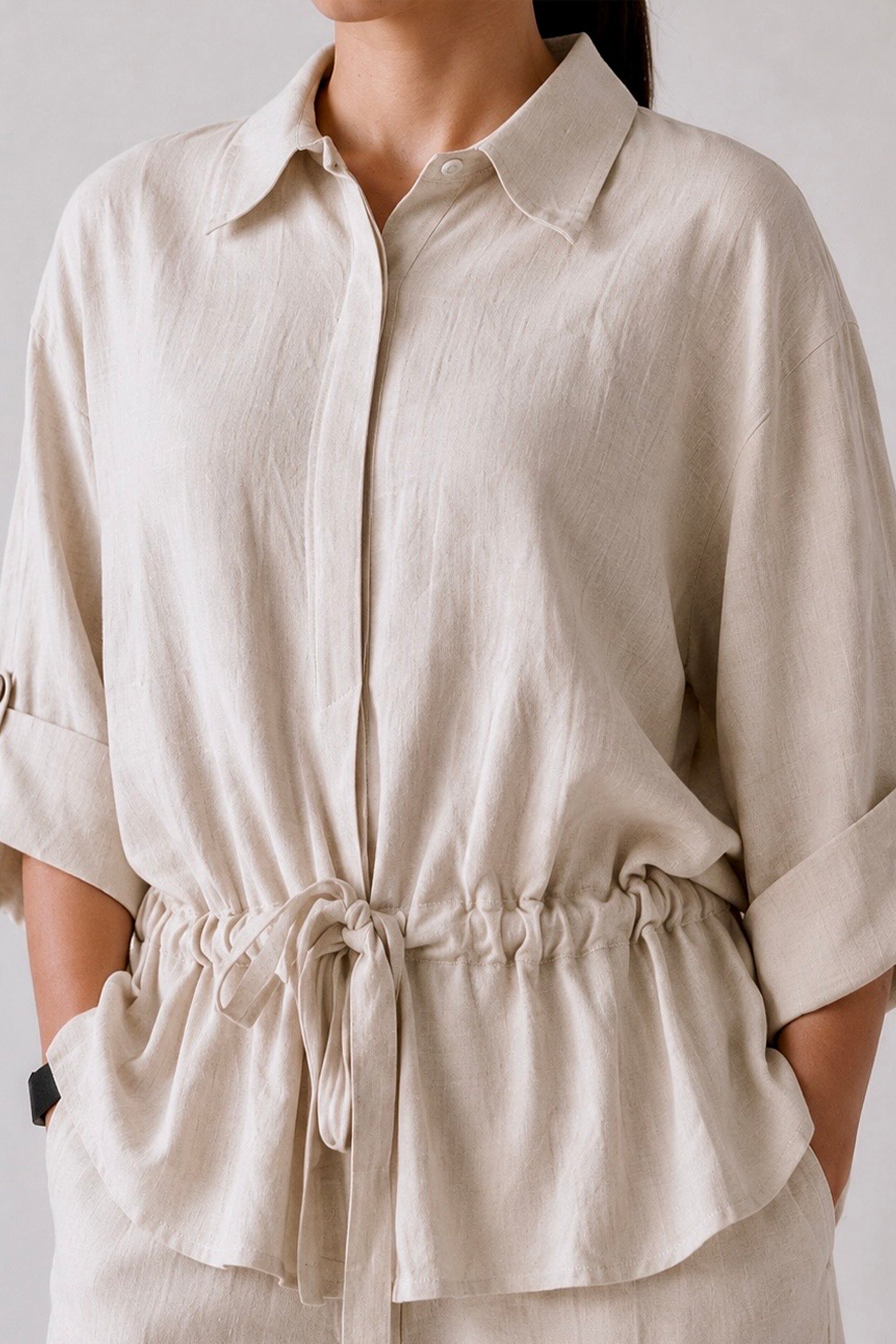 Flat lay of the off white cinched waist top, by SOLA Pakistan.
