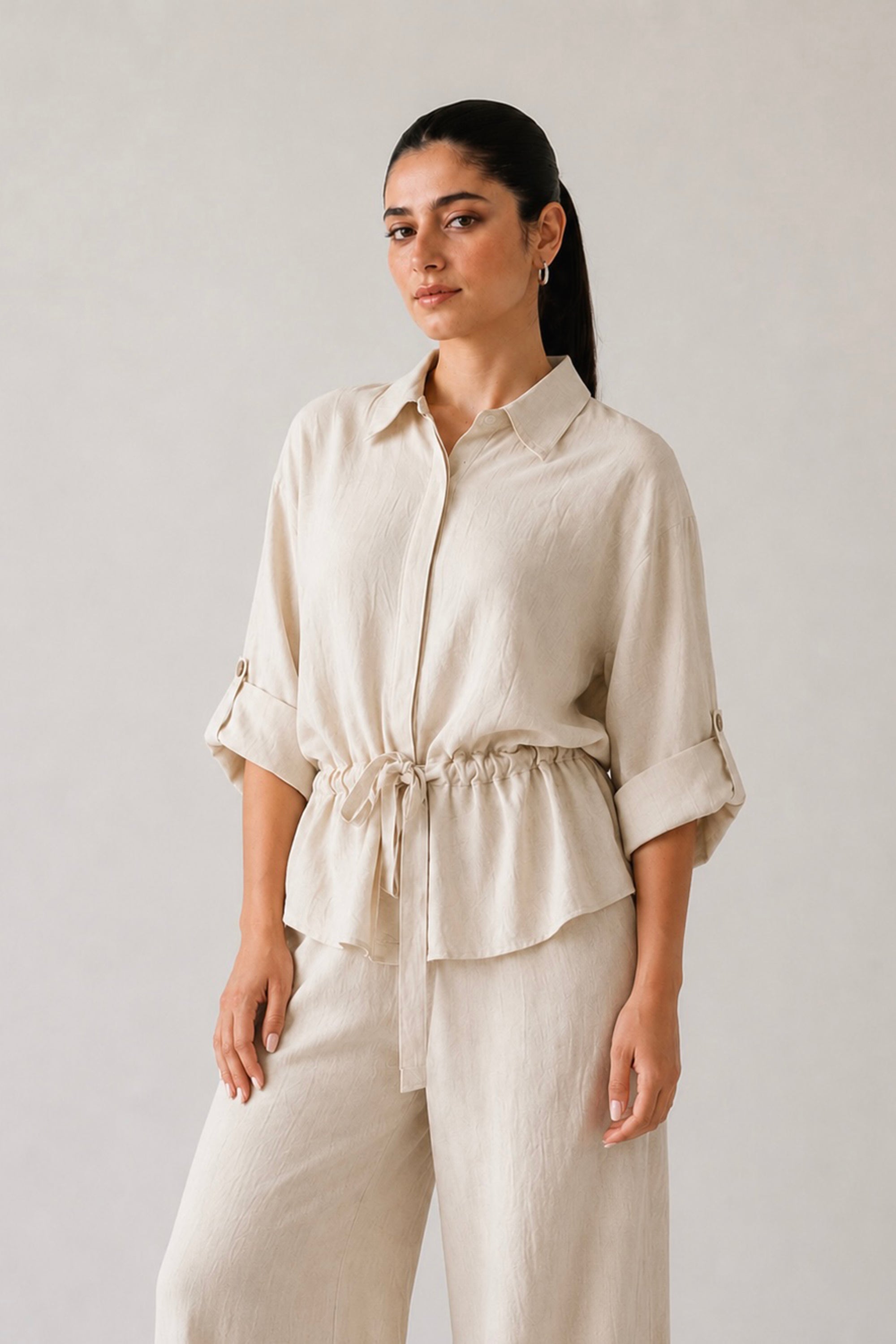 Off white cinched waist top in cotton-linen blend, worn by a model, by SOLA Pakistan.