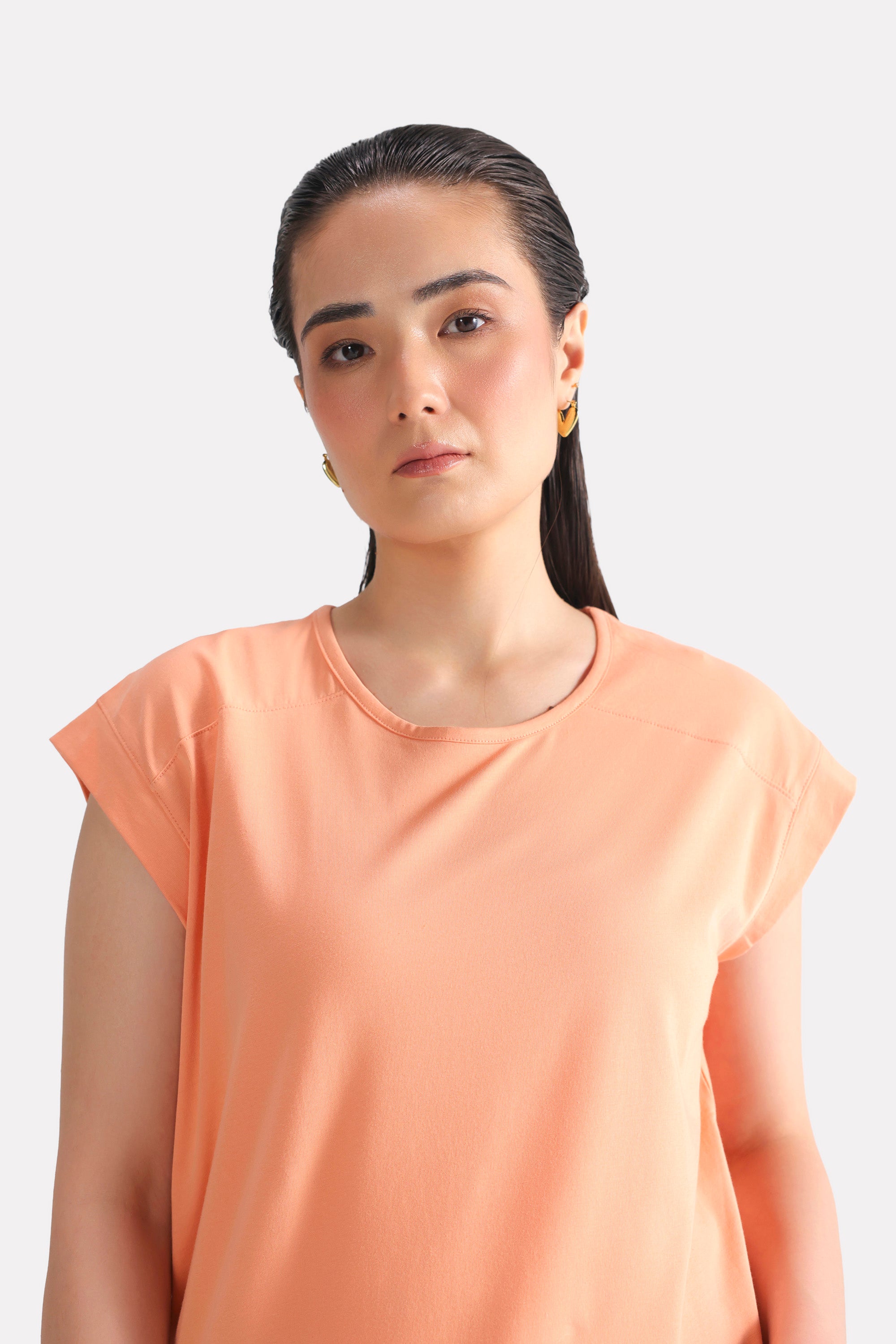 Peach (apricot) relaxed shoulder-tab t-shirt, alternate angle, by SOLA Pakistan.