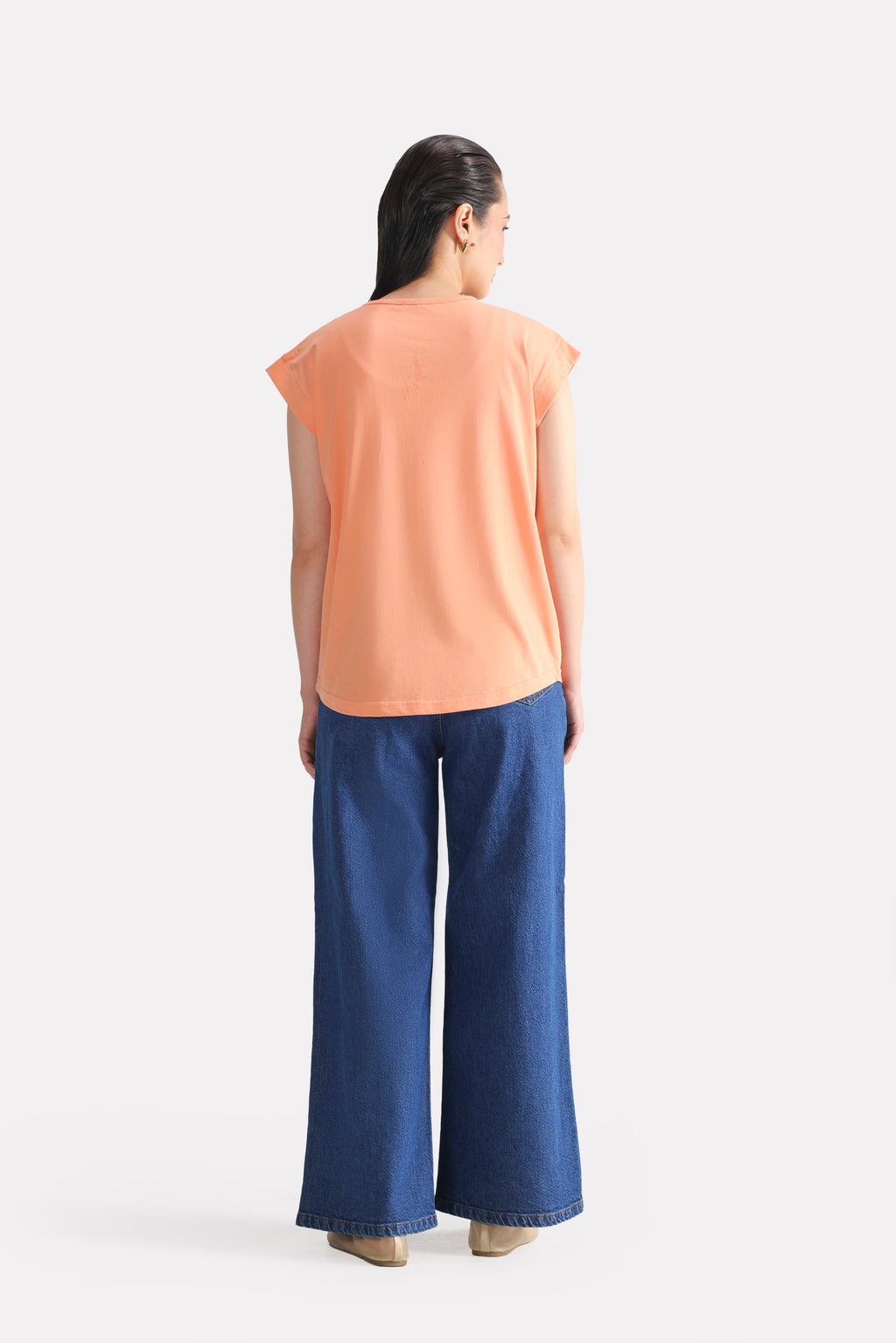 Flat lay of the peach (apricot) relaxed shoulder-tab t-shirt, by SOLA Pakistan.