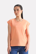 Peach (apricot) relaxed shoulder-tab t-shirt in cotton, worn by a model, by SOLA Pakistan.