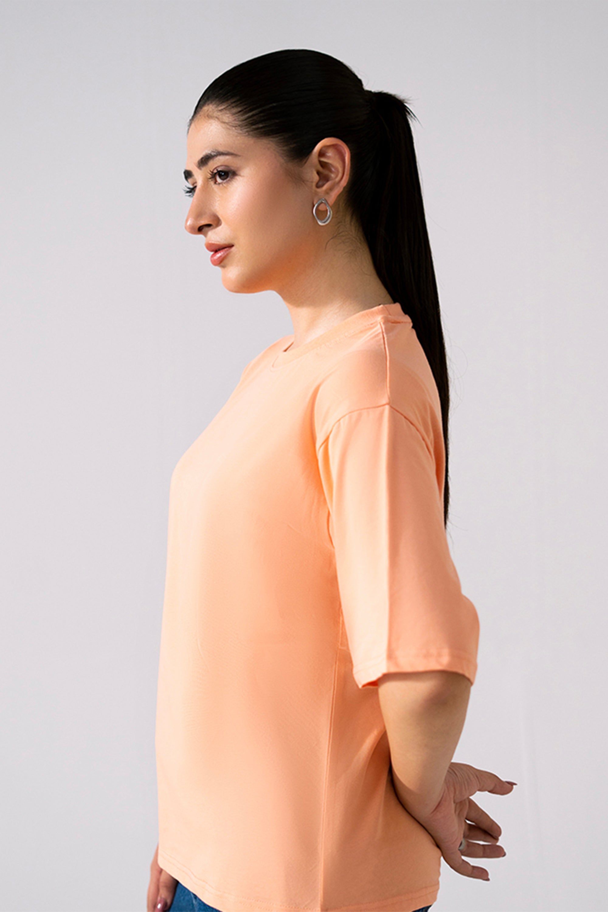Close-up detail on the peach (apricot) round neck t-shirt, by SOLA Pakistan.