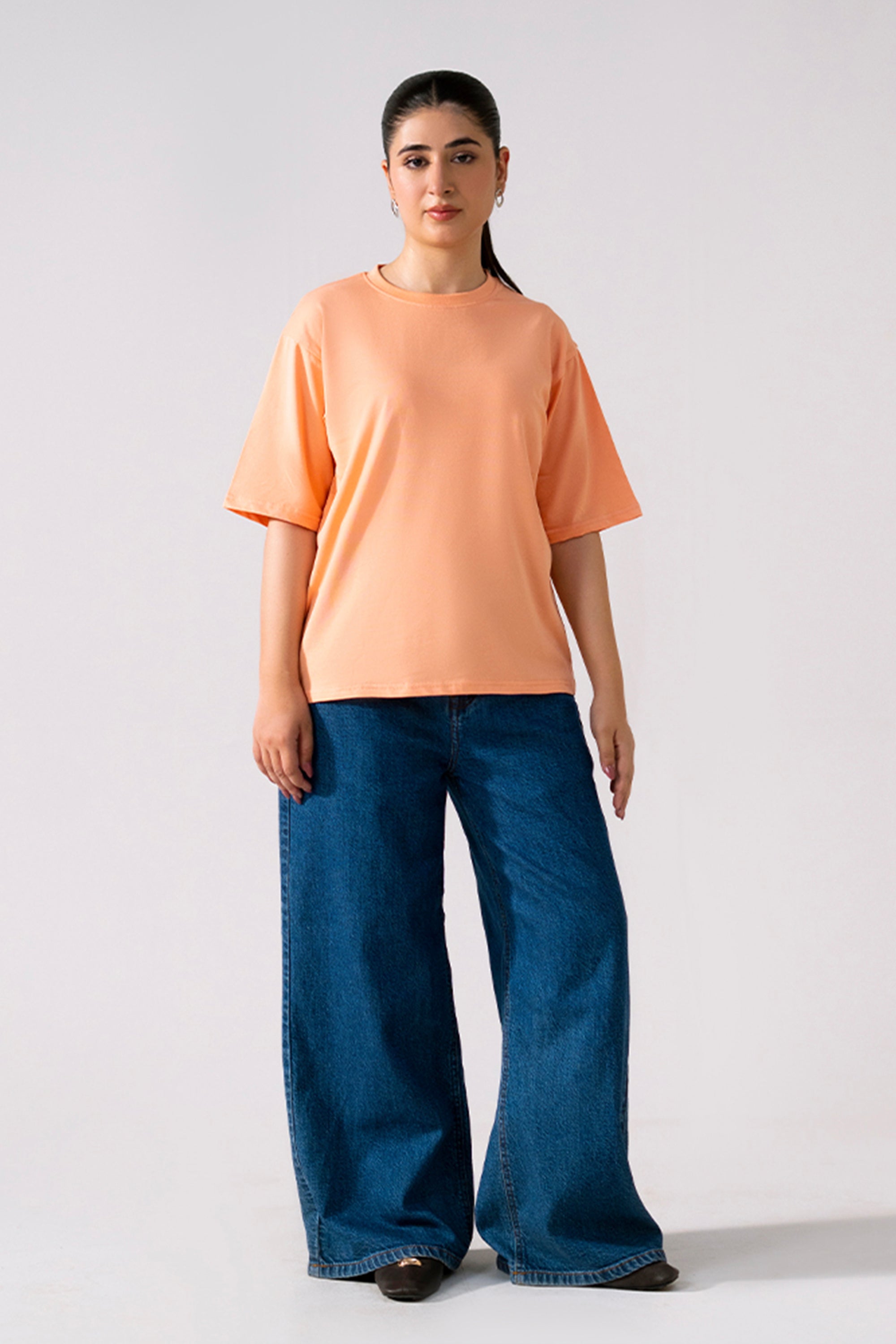 Peach (apricot) round neck t-shirt shown in a styled fit, by SOLA Pakistan.