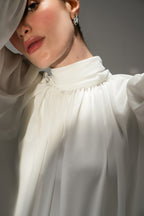 Close-up detail on the pearl white gathered highneck blouse, by SOLA Pakistan.