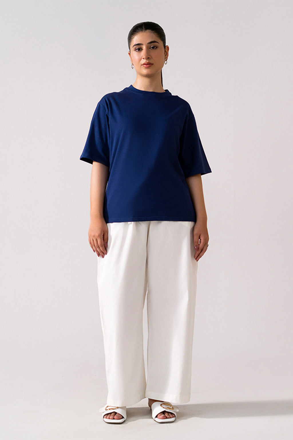 White cotton straight trousers, worn by a model, by SOLA Pakistan.