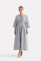 White & grey cinched waist seersucker dress in viscose-cotton blend, worn by a model, by SOLA Pakistan.