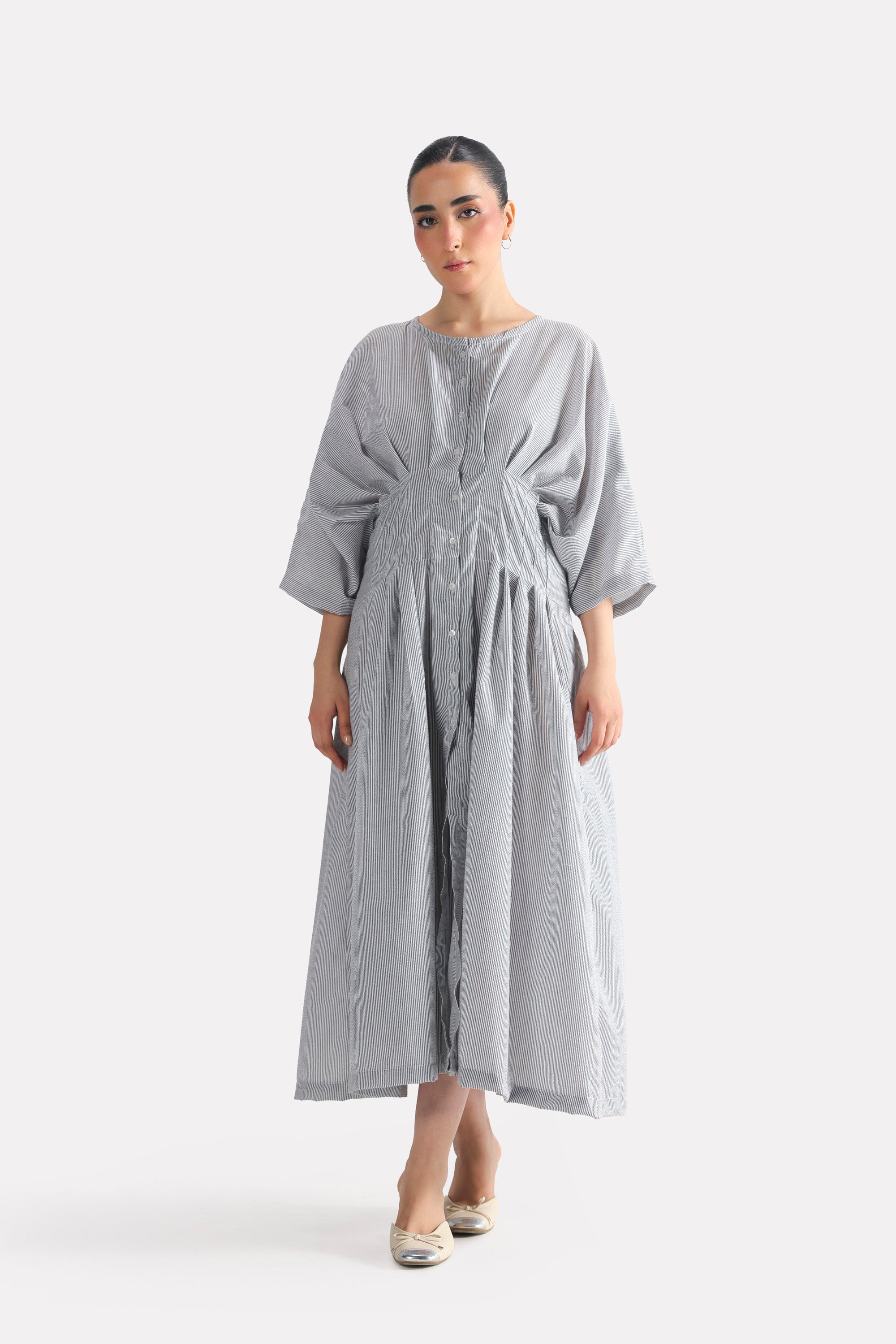 White & grey cinched waist seersucker dress in viscose-cotton blend, worn by a model, by SOLA Pakistan.