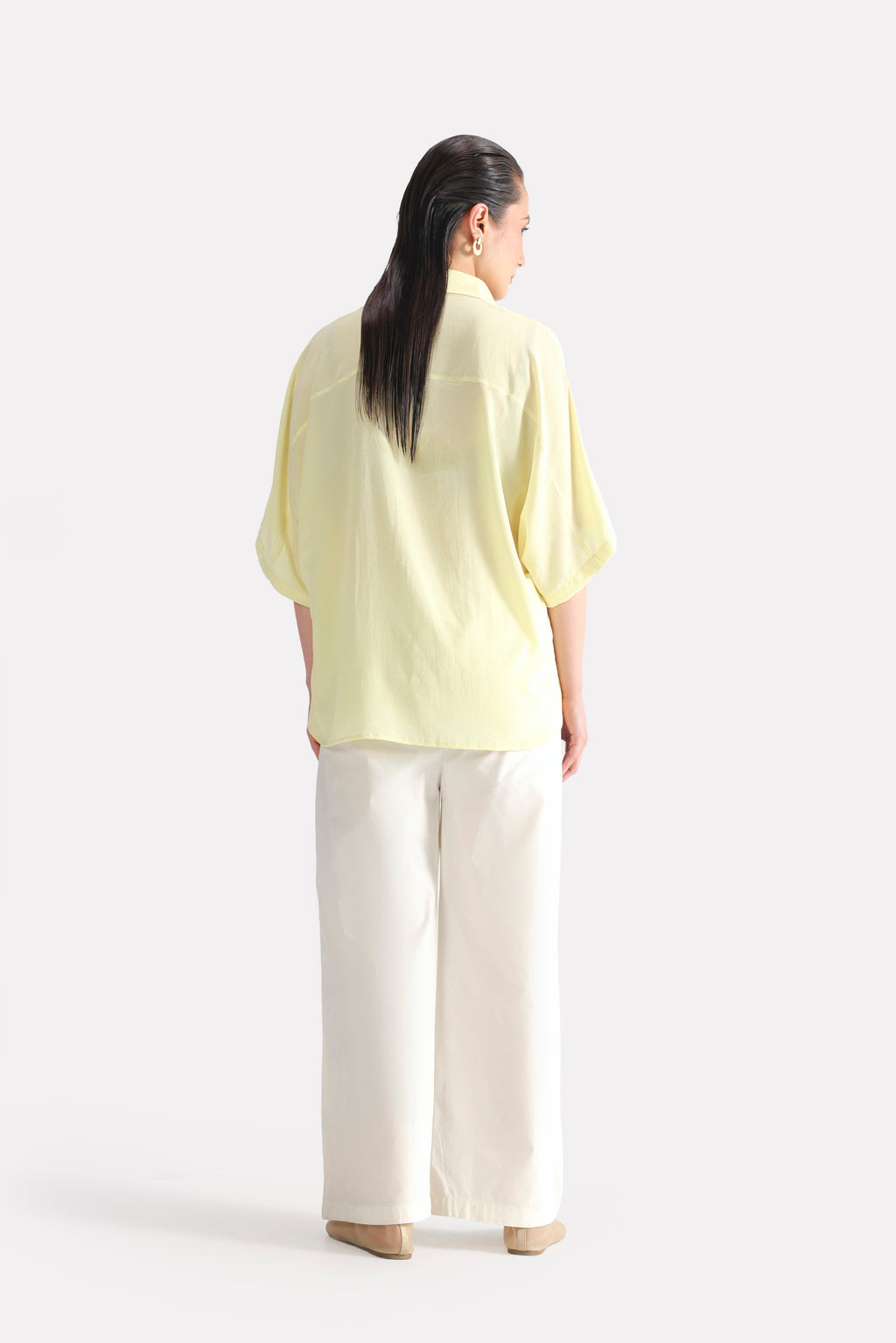 Close-up detail on the yellow bubble hem oversized top, by SOLA Pakistan.