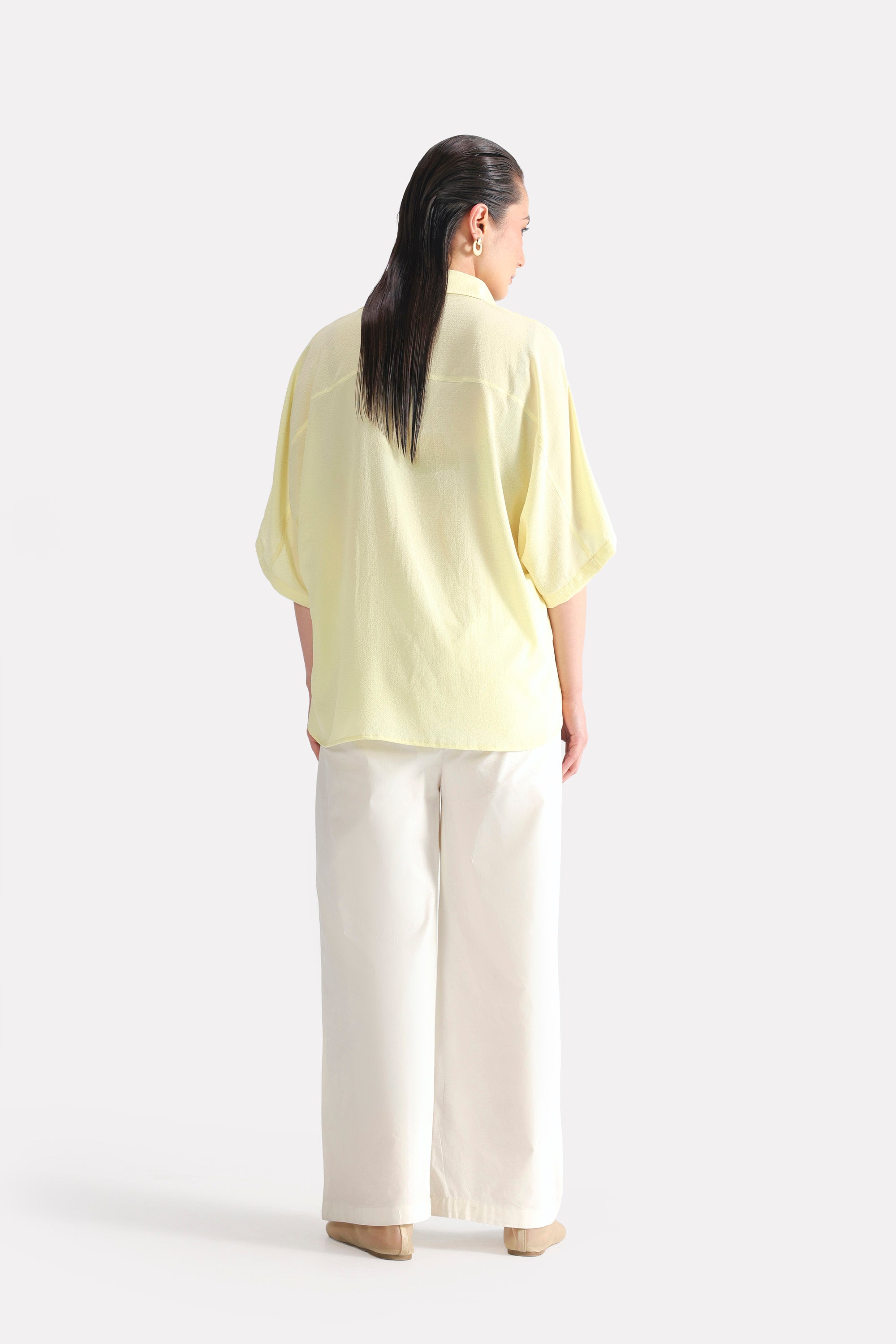 Close-up detail on the yellow bubble hem oversized top, by SOLA Pakistan.
