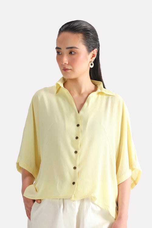 Yellow bubble hem oversized top in viscose-cotton blend, worn by a model, by SOLA Pakistan.